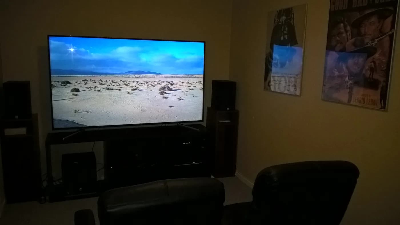 Heimkino-Setup mit großem Smart-TV und Surround-Sound-Lautsprechern